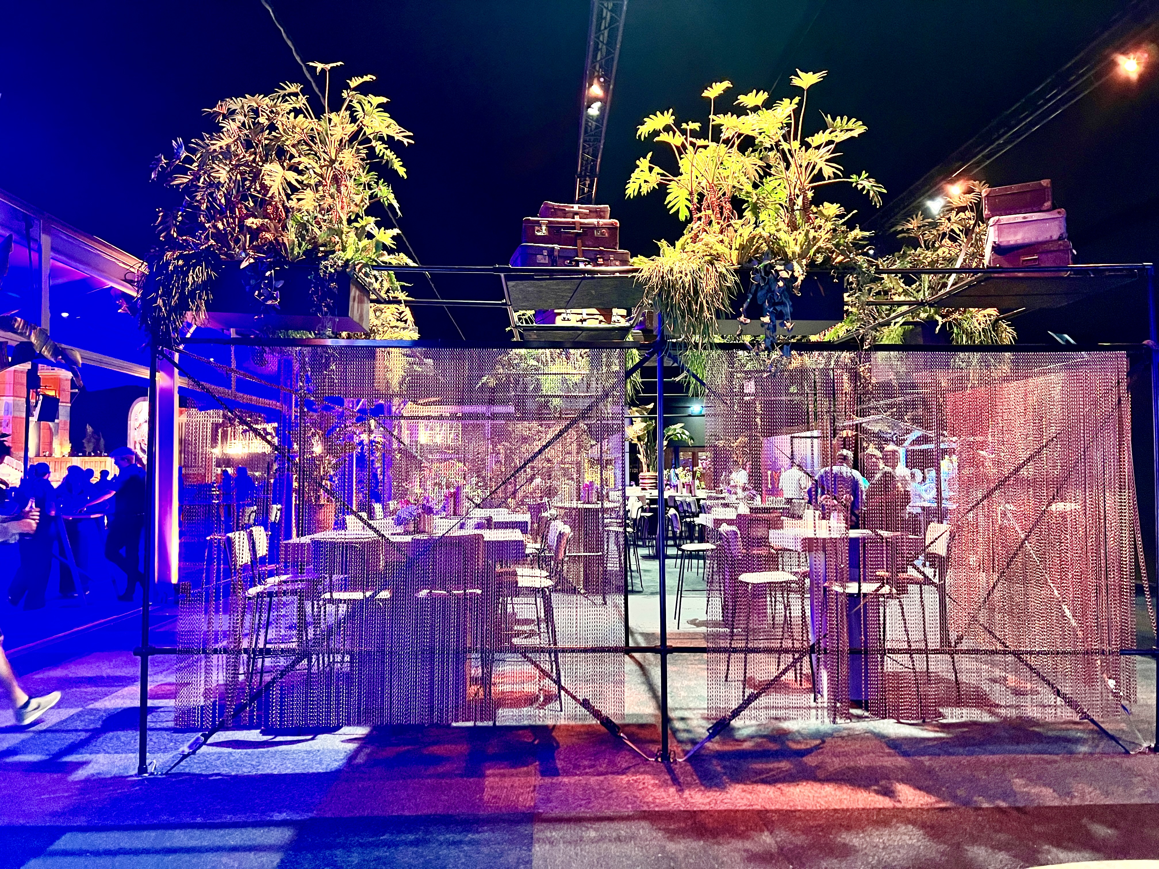 Rahmenkonstruktion mit aufgesetzter Pflanzendekoration und Kettenvorhängen aus Kupfer als Raumtrenner - Platinum Club Parookaville Festivals 2025 - Eventausstattung für Events - BasdeBoer